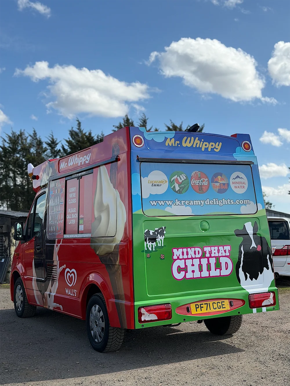 The back of a Kreamy Delights ice cream van, with the kreamydelights.com web address and a Mind That Child sign
